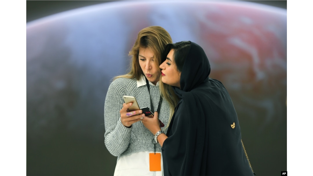 Journalists checkout the latest features of a mobile phone at the Apple Store ahead of their grand opening in Dubai, United Arab Emirates, Oct. 27, 2015.