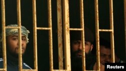 Prisoners are seen behind bars in a Benghazi jail in this February 22, 2012, file photo.