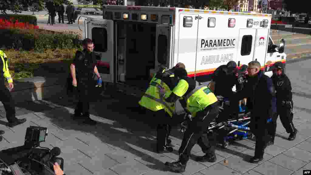 La police et les ambulanciers transportent un soldat canadien blessé à Ottawa, Canada, le 22 octobre 2014.. 