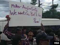 A Burmese man holds up a sign saying he wants to return to Myanmar during Aung San Suu Kyi's trip to Thailand, June 23, 2016. (Z. Aung/VOA)