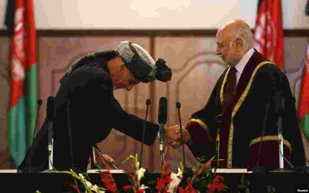 Afghanistan's new President Ashraf Ghani Ahmadzai shakes hands with Afghanistan's Chief Justice Abdul Salam Azimi as he takes the oath during his inauguration as president in Kabul, Sept. 29, 2014.