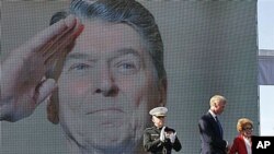 Former first lady Nancy Reagan is helped on stage by Frederick J. Ryan Jr., center, Reagan Foundation Chairman, as Marine Lt. Gen. George J. Flynn looks on after a wreath laying ceremony at memorial of her husband, former US President Ronald Reagan during