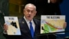 Perdana Menteri Israel Benjamin Netanyahu memegang poster saat berpidato pada Sidang Umum Perserikatan Bangsa-Bangsa ke-79, Jumat, 27 September 2024. (Foto: AP)