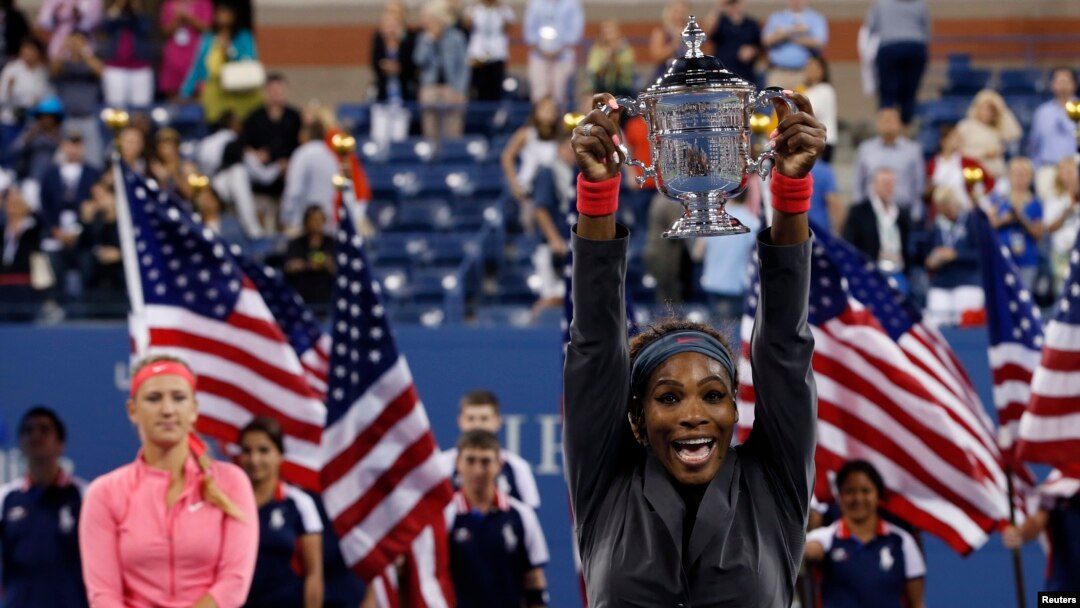 Serena Williams mengangkat piala kemenangannya setelah mengalahkan Victoria Azarenka dari Belarus (kiri) dalam final pertandingan tenis tunggal putri memperebutkan piala Amerika Terbuka di New York (8/9).