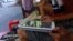 FILE - A customer uses his tablet to access the Internet at a 'wifi coffee shop' in downtown Hanoi.