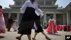 Hombres y mujeres norcoreanos participan en un baile masivo el martes, 25 de abril de 2017, en Pyongyang, Corea del Norte, en conmemoración del 85 aniversario del Ejército del país.