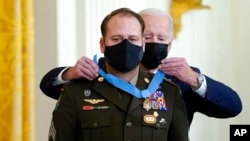 拜登总统在白宫东厅为陆军军士长普拉姆利戴上荣誉勋章。(2021年12月16日)