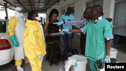 A health worker sprays a colleague with disinfectant during a training session for Congolese health workers to deal with Ebola virus in Kinshasa October 21, 2014.