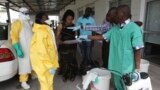 FILE - A health worker sprays a colleague with disinfectant during a training session for Congolese health workers to deal with Ebola virus in Kinshasa, Oct. 21, 2014.