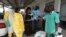 Un agent de santé pulvérise un collègue avec un désinfectant lors d'une séance de formation pour les agents de santé congolais pour lutter contre le virus Ebola à Kinshasa le 21 octobre 2014. 