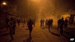 Anti-government protesters run from tear gas in Dakar on January 27, 2012.