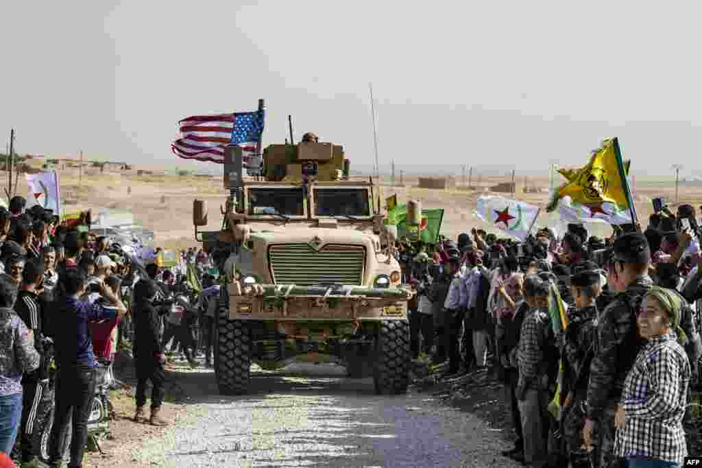 Syrian Kurds gather around a U.S. armored vehicle during a demonstration against Turkish threats on the outskirts of Ras al-Ain town in Syria's Hasakeh province near the Turkish border, Oct. 6, 2019.