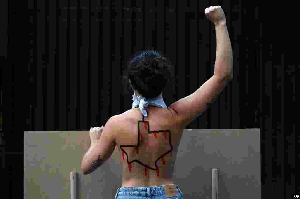 A Femen activist with the U.S. state of Texas drawn on her back protests against the new abortion law in Texas, in front of the U.S. consulate in Madrid, Spain.