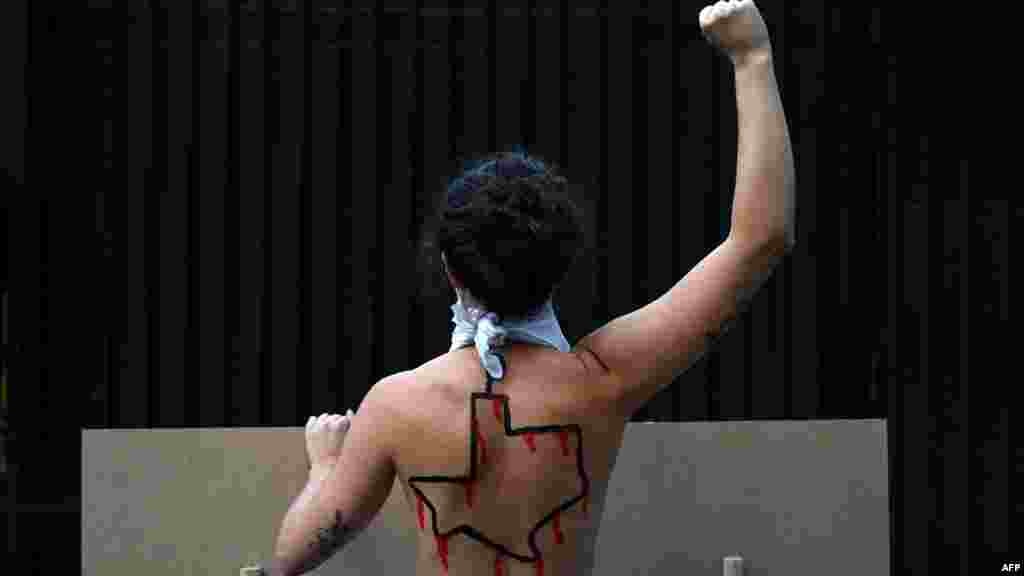 An activist who is part of the Femen group is seen with the American state of Texas drawn on her back protests against the new abortion law in Texas in front of the U.S. consulate in Madrid, Spain.