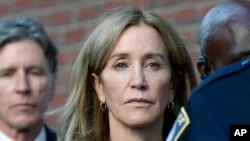 FILE - Felicity Huffman leaves federal court with her brother Moore Huffman Jr., after she was sentenced in a nationwide college admissions bribery scandal, Sept. 13, 2019, in Boston. 