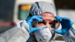 Corporal Mathias Jahn, member of the German armed forces Bundeswehr, fixes his glasses beside a mobile coronavirus test station in Gera, Germany, Wednesday, April 1, 2020.