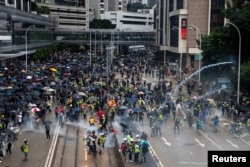 Anti-government protesters run away from tear gas during a demonstration in Wan Chai district in Hong Kong, China October 6, 2019.