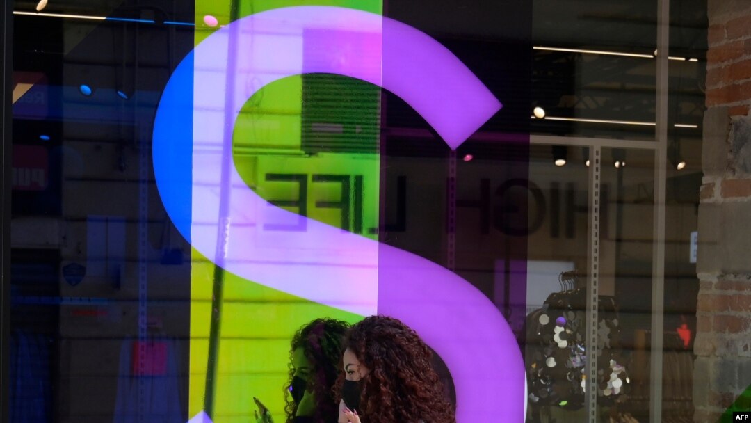 Una mujer usando máscara de protección habla por teléfono frente a una tienda en Ciudad México, México, el 1 de diciembre de 2020.