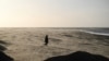 A person walks among the blows sand on St Annes beach in Lytham St Annes, near Blackpool, north-west England on Jan. 24, 2025, as storm Eowyn brings winds of 100 mph to the UK and Ireland. 