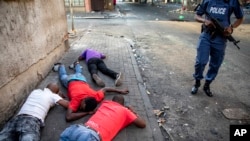 People lay on the ground after being arrested in Jeppestown, Johannesburg, Tuesday, Sept. 3, 2019. Police have struggled to stop looters who have been targeting businesses as unrest broke out in several spots in and around the city. (AP Photo)