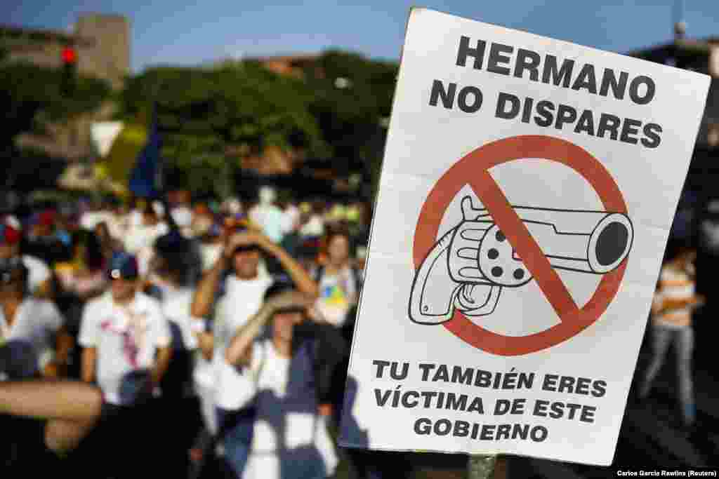 Durante um comício para promover a paz na capital apoiantes do líder da oposição Leopoldo Lopez, agitam cartaz que diz: "Irmão, não atire. Você também é uma vítima deste governo", 20 de Fevereiro, 2014.