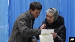 Cử tri cao tuổi được giúp đỡ tại một địa điểm bầu cử ở Kiev, Ukraina, ngày 28/10/2012 
