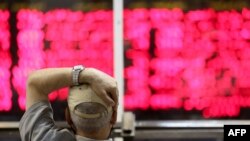 FILE - An Iranian man monitors the stock market at Tehran Stock Exchange, July 1, 2019.