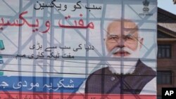 An Indian paramilitary soldier patrols past a hoarding of Indian Prime Minister Narendra Modi in Srinagar, Indian controlled Kashmir, June 24, 2021.