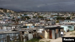 Residents walk through shacks in Cape Town's crime-ridden Khayelitsha township, July 9, 2012.