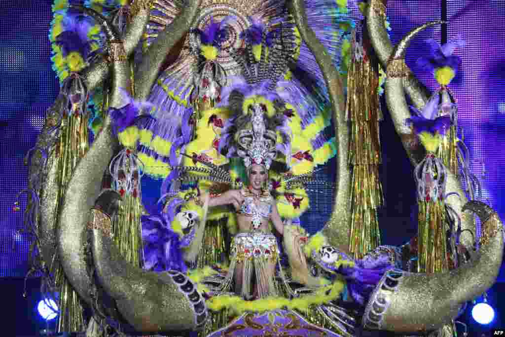 A nominee for Queen of the Carnival of Santa Cruz shows off her outfit under the watchful eyes of the jury in Santa Cruz de Tenerife on the Spanish Canary island of Tenerife, Feb. 26, 2014.
