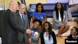 Former U.S. President George W. Bush and New Orleans Mayor Mitch Landrieu (L) talk to students at Warren Easton Charter High School one day before the ten year anniversary of Hurricane Katrina in New Orleans, Aug. 28, 2015. 