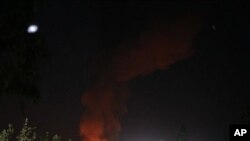 A plume of smoke and fire is seen after an airstrike in Tripoli, Libya, June 14, 2011.