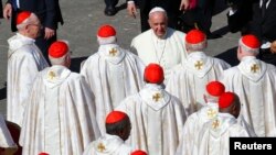 FILE - Pope Francis greets cardinals at the end of a mass for the beatification of former pope Paul VI in St. Peter's square at the Vatican, Oct. 19, 2014. 