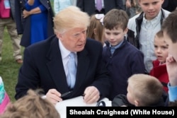 President Donald J. Trump joins kids coloring and signing cards for U.S. Troops, at the White House Easter Egg Roll, April 2, 2018, in Washington, D.C. (Official White House Photo by Shealah Craighead)