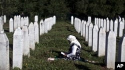 FILE - A woman is seen mourning amid tomb stones at the Potocari memorial complex near Srebrenica, Bosnia and Herzegovina, where victims of the Srebrenica massacre are buried, July 11, 2015.