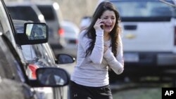 Mulher desesperada aguarda notícias sobre a sua irmã, uma professora na Escola Primária de Sandy Hook, em Newtown, no estado de Connecticut.