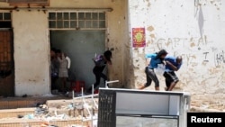 Locals react as they are shot at by a policeman (not in the picture) while looting from a shop, believed to be owned by a foreigner, during service delivery protests in Mohlakeng, west of Johannesburg February 4, 2015. Local media reported that violence b