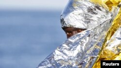 FILE - A migrant waits to disembark from a rescue vessel in the Italian harbor of Vibo Marina, Italy, Oct. 22, 2016. As of Dec. 1, Italy has taken in more than 173,000 boat migrants during 2016. 