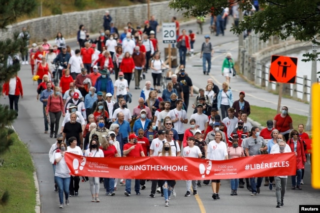 Supporters of Michael Kovrig and Michael Spavor march to mark 1,000 days since the Canadians were arrested in China, during a protest in Ottawa, Ontario, Canada September 5, 2021. REUTERS/Blair Gable