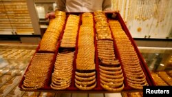 FILE - A salesman displays a tray of gold bangles at a jewelery shop in Singapore, Oct. 7, 2009. Cambodia’s records indicate what some see as a suspiciously high amount of gold imported from Singapore.