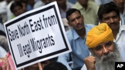 FILE - An Indian supporter of the Bharatiya Janata Party (BJP) holds a placard during a protest against what participants say is the illegal migration of Muslims from Bangladesh to the northeastern state of Assam, in New Delhi, India, Aug. 18, 2012.