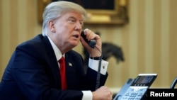 FILE - U.S. President Donald Trump speaks by phone in the Oval Office at the White House in Washington, Jan. 29, 2017.