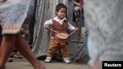 A child member of Cantagallo, an Indigenous Shipibo-Konibo community, plays the drums during a visit of Peru's President Pedro Pablo Kuczynski, in Lima, Peru Dec. 16, 2016.