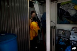 Homeless Kimberly Gardea, 35, walks out of a shower stall inside a trailer built to provide showers to homeless people living on the Santa Ana River trail in Anaheim, California, Dec. 2, 2017.