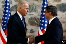 FILE - U.S. Vice President Joe Biden, left, shakes hands with Turkish Prime Minister Ahmet Davutoglu, right, following a joint news conference after their meeting in Dolmabahce Palace in Istanbul, Jan. 23, 2016.