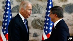 U.S. Vice President Joe Biden, left, shakes hands with Turkish Prime Minister Ahmet Davutoglu, right, following a joint news conference after their meeting in Dolmabahce Palace in Istanbul, Jan. 23, 2016.