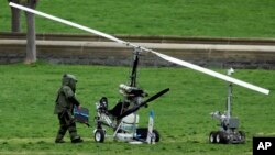 A member of a bomb squad checks a gyrocopter sitting on the West Lawn of the Capitol in Washington, April 15, 2015. 