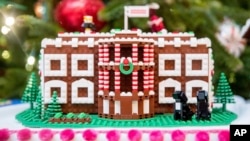 FILE - In this Tuesday, Nov. 29, 2016 file photo a LEGO model of the White House, one of fifty-six LEGO gingerbread houses, one for each state and territory, is displayed in the trees in the State Dinning Room at the White House during a preview of the 2