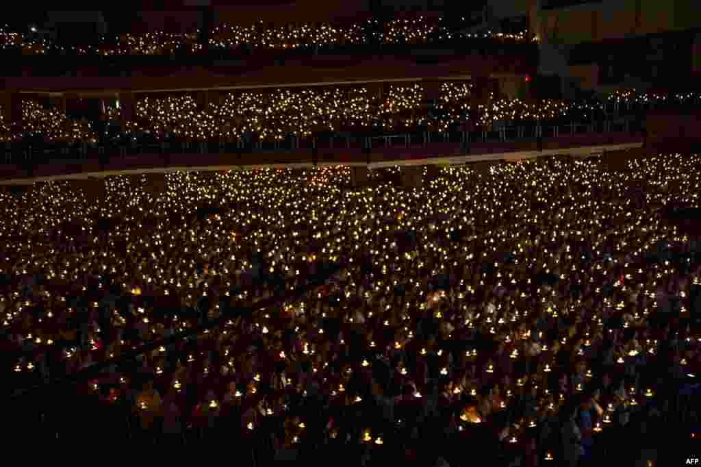 Christian faithfuls hold candles as they attend a mass service on Christmas eve in Surabaya, Indonesia.