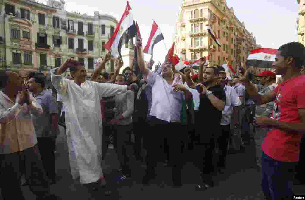 Supporters of the Muslim Brotherhood&#39;s presidential candidate Mohamed Morsi carry a poster for him as they celebrate his victory in the presidential elections in Cairo, June 24, 2012. (Reuters)